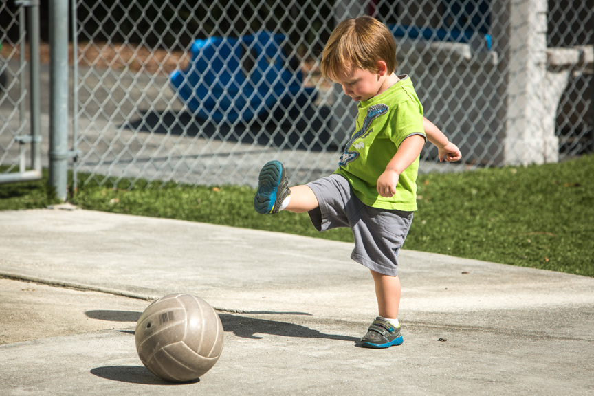 Young boy kicking soccer ball