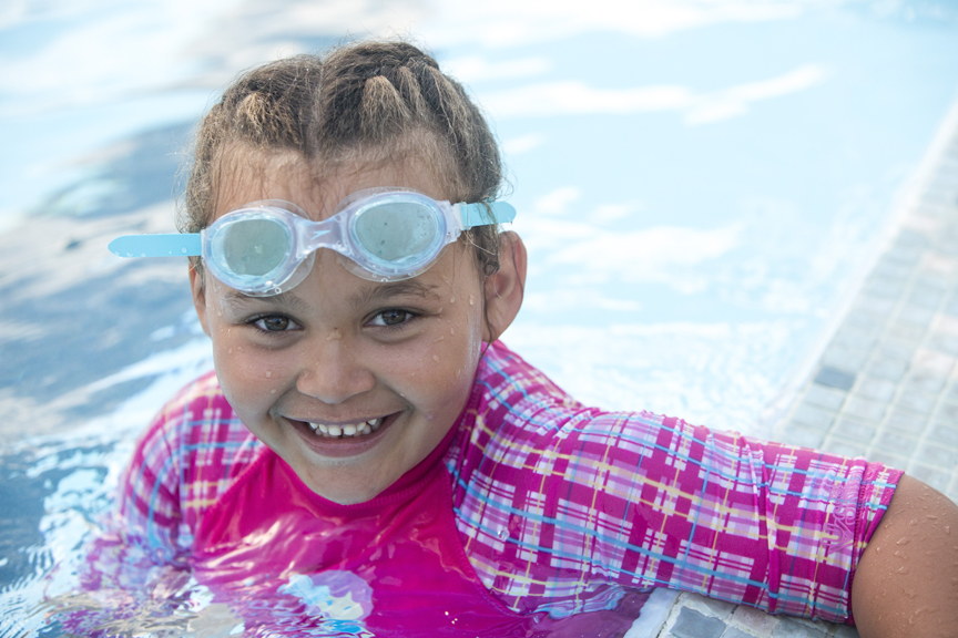 Girl in swimming pool wearing goggles
