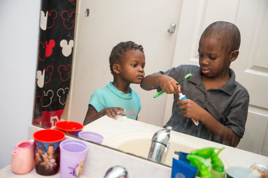 Young boy and young girl brushing their teeth