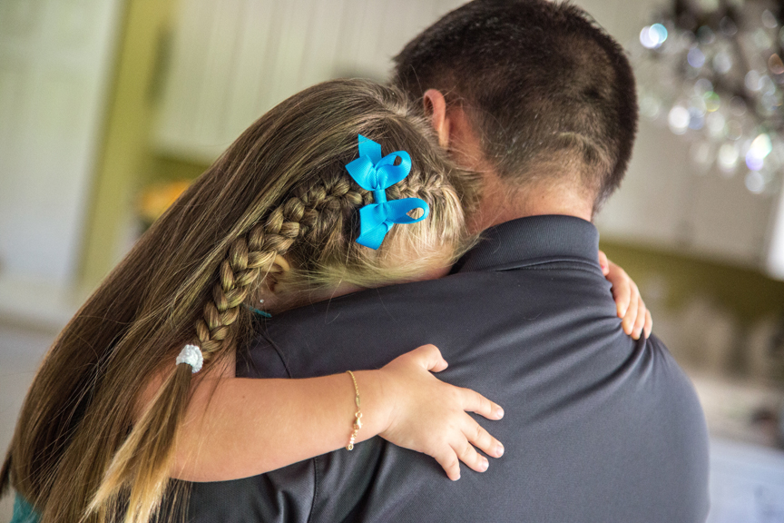 Father holding and carrying young daughter
