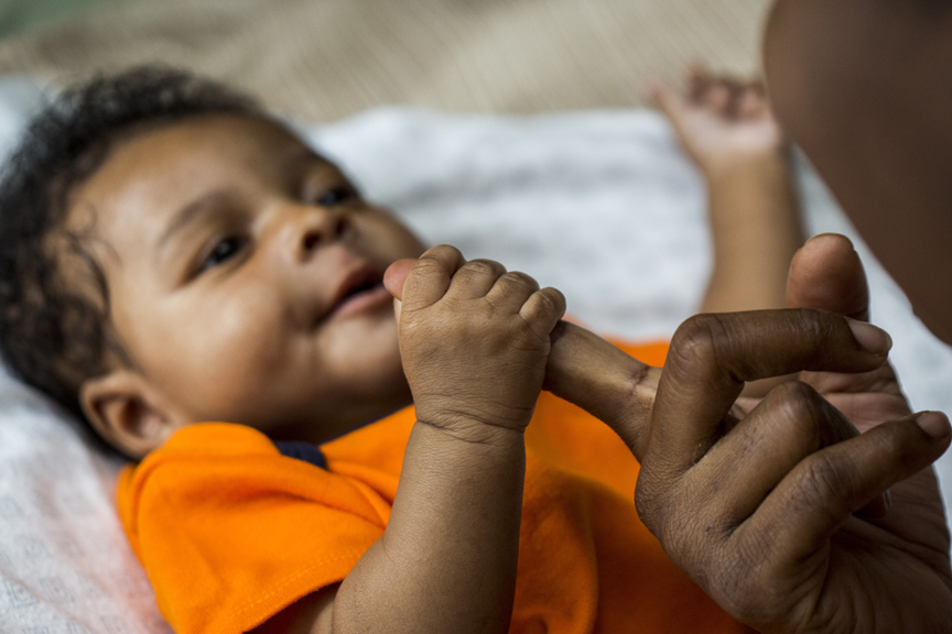 Infant holding mothers finger