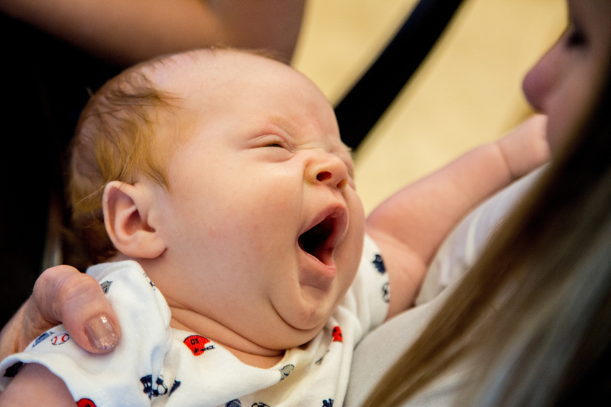 Infant being held while yawning