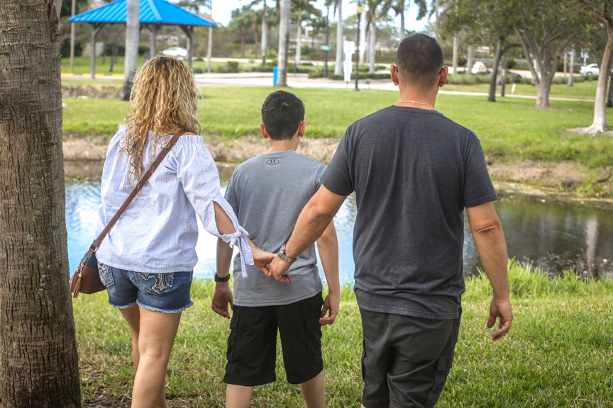 Mother and father holding hands walking in a park