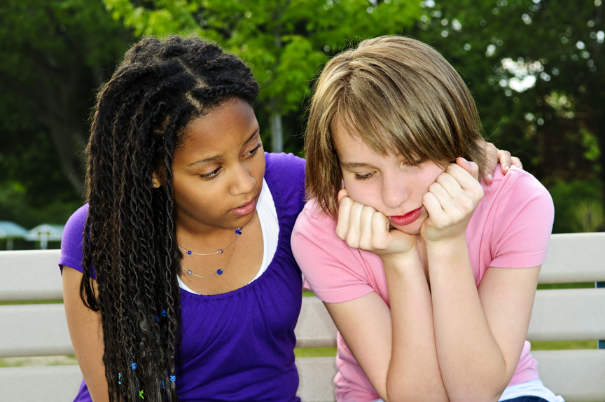 Teenage girls consoling one another