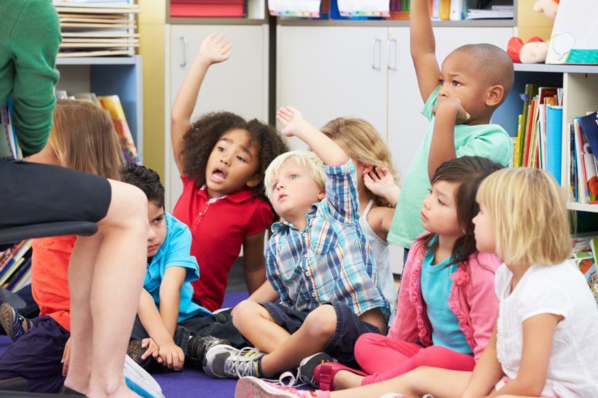 Classroom full of students with their hands raised