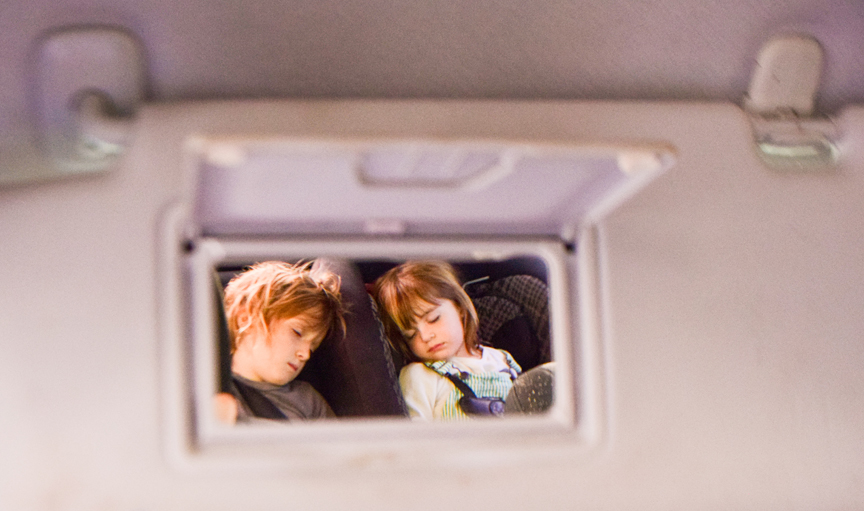 Children in carseats seen through mirror in visor