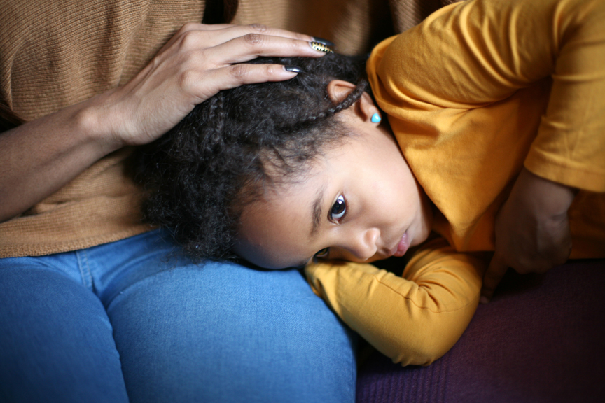 Young girl laying in woman's lap