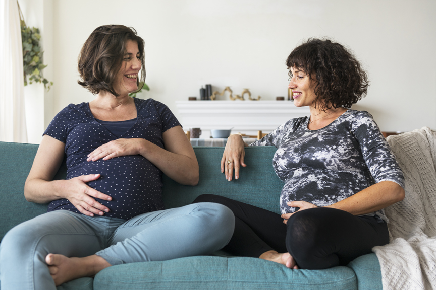 Pregnant women talking on couch
