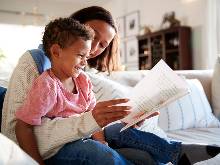 Boy reading with mother.