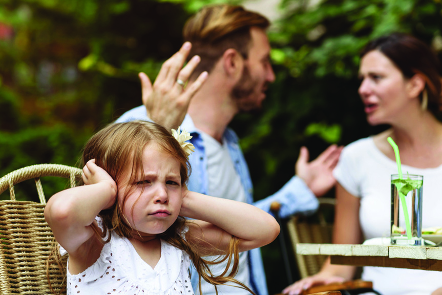 Girl covering ears while parents fight