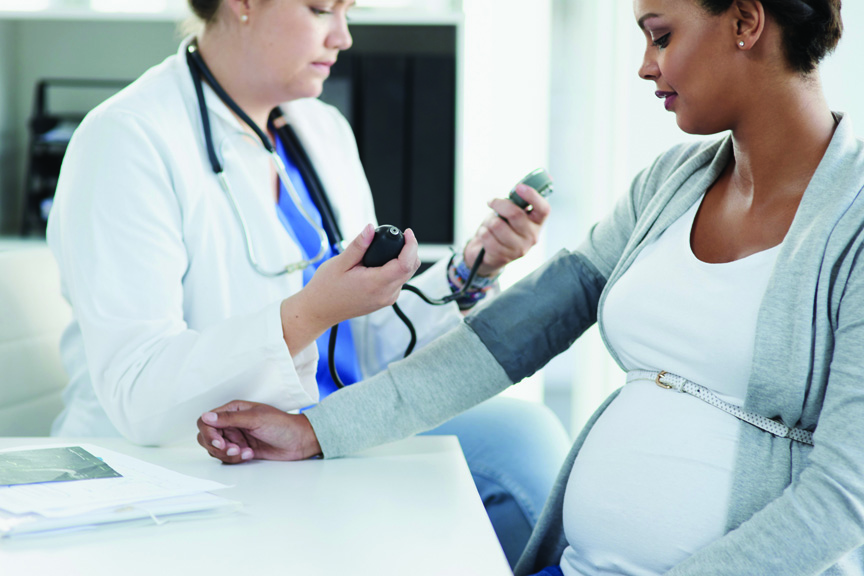 Doctor taking a pregnant woman's blood pressure