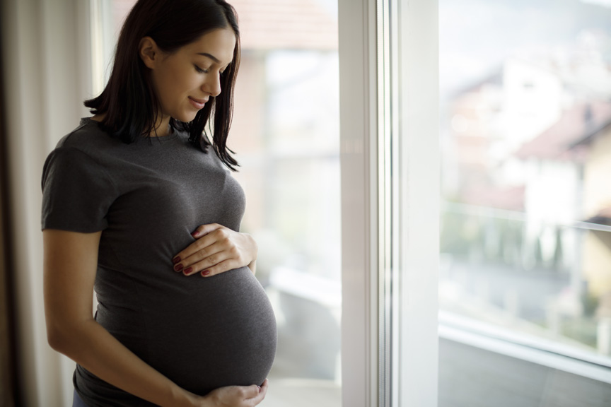 Pregnant mom gently holding stomach
