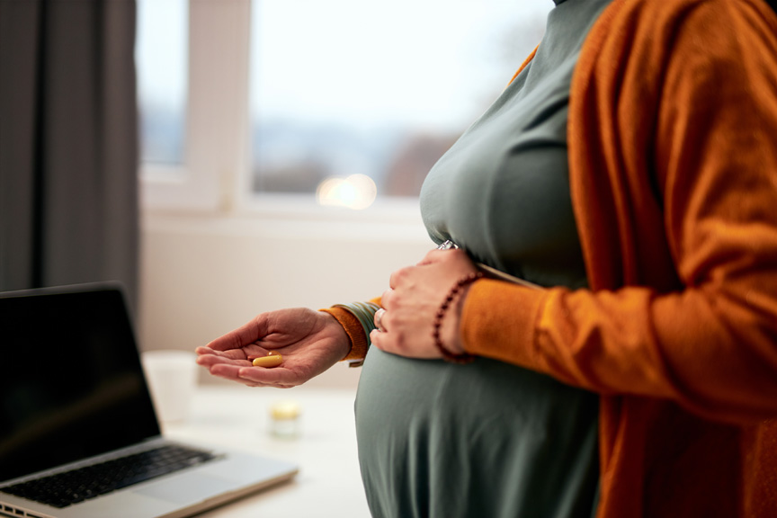 Pregnant mom holding vitamins