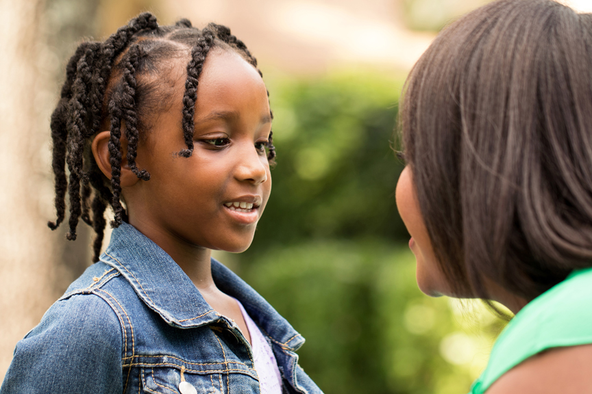 Woman and girl smiling at each other