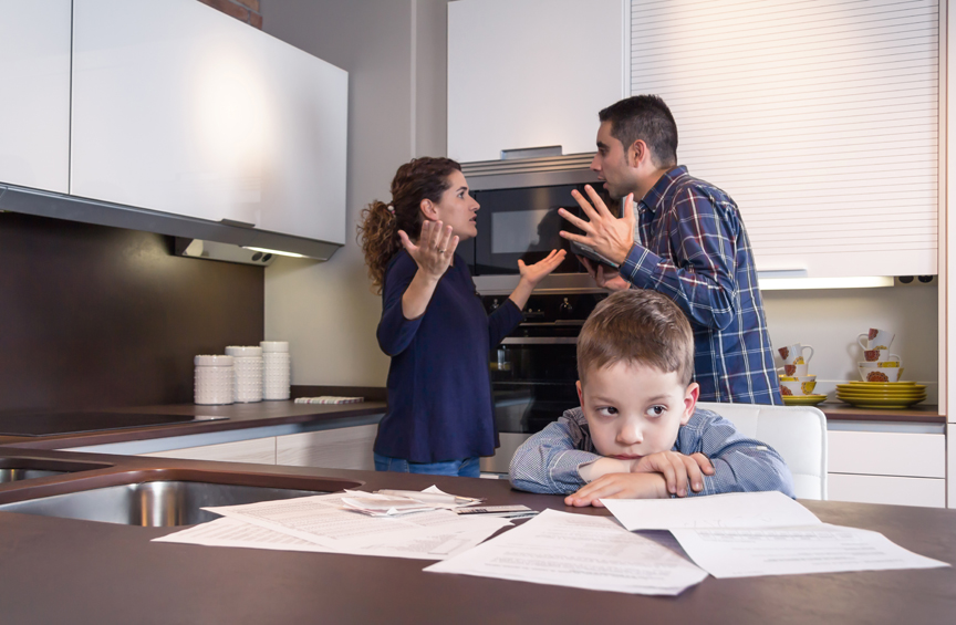 Child looking sad while adults fight in background