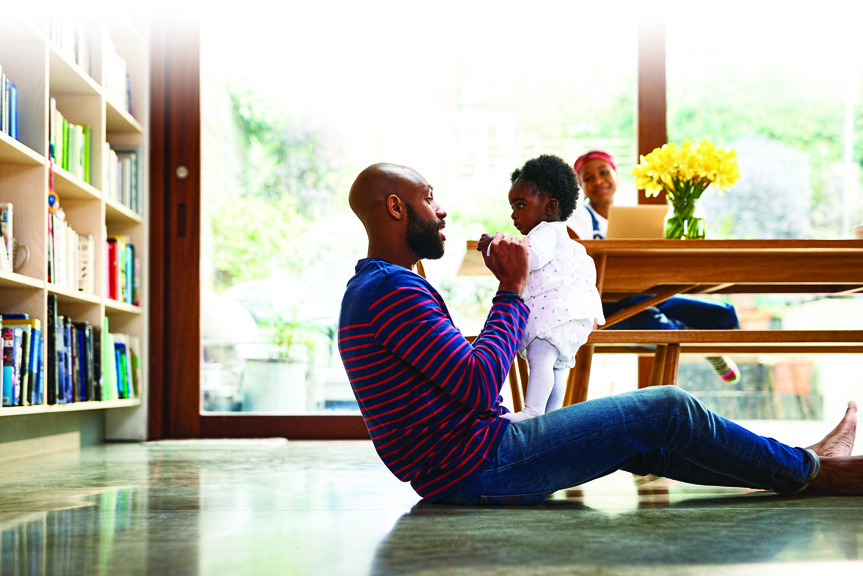 Dad playing with baby in living room