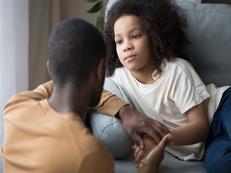 Little girl listens closely as Dad talks to her.