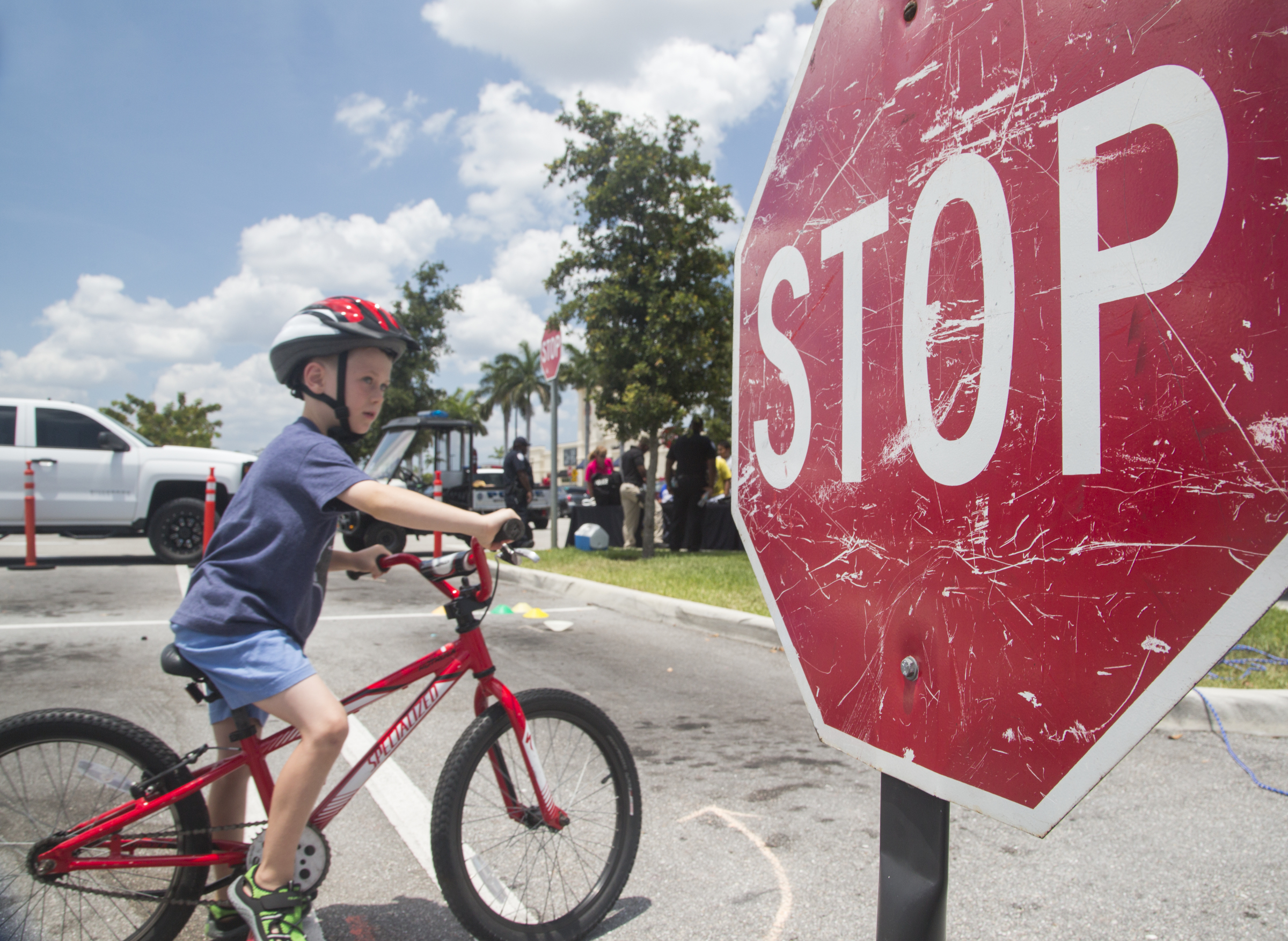 Boy wearing helmet riding bike in front of a stop sign