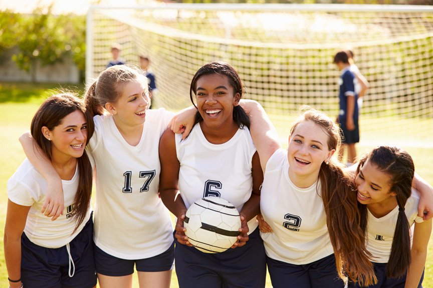 Teen girls playing soccer.